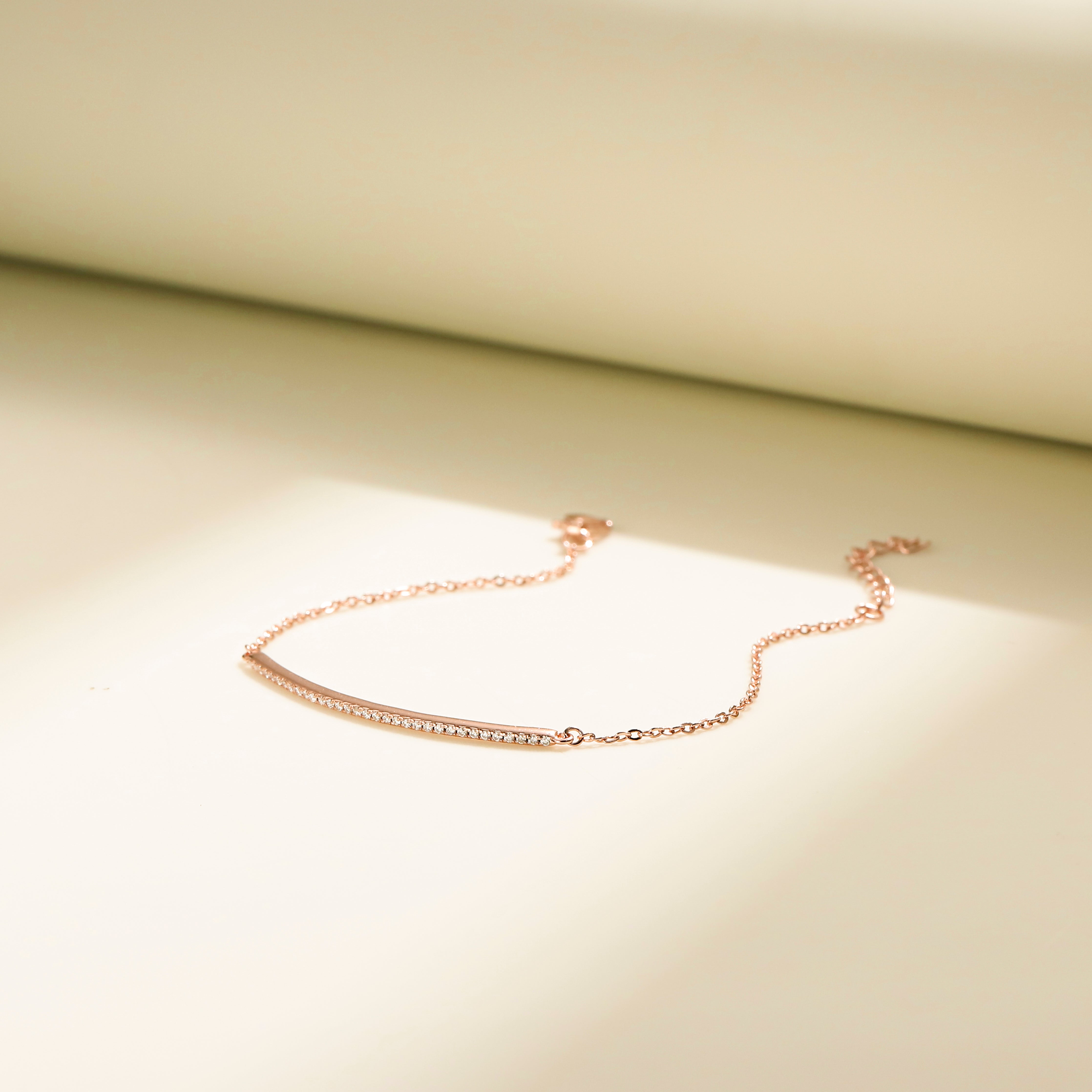 Minimalist Arc Charm Bracelet in 18 carat rose gold vermeil, adorned with a Moissanite arc design and an adjustable chain, perfect for daily wear or as a thoughtful gift.