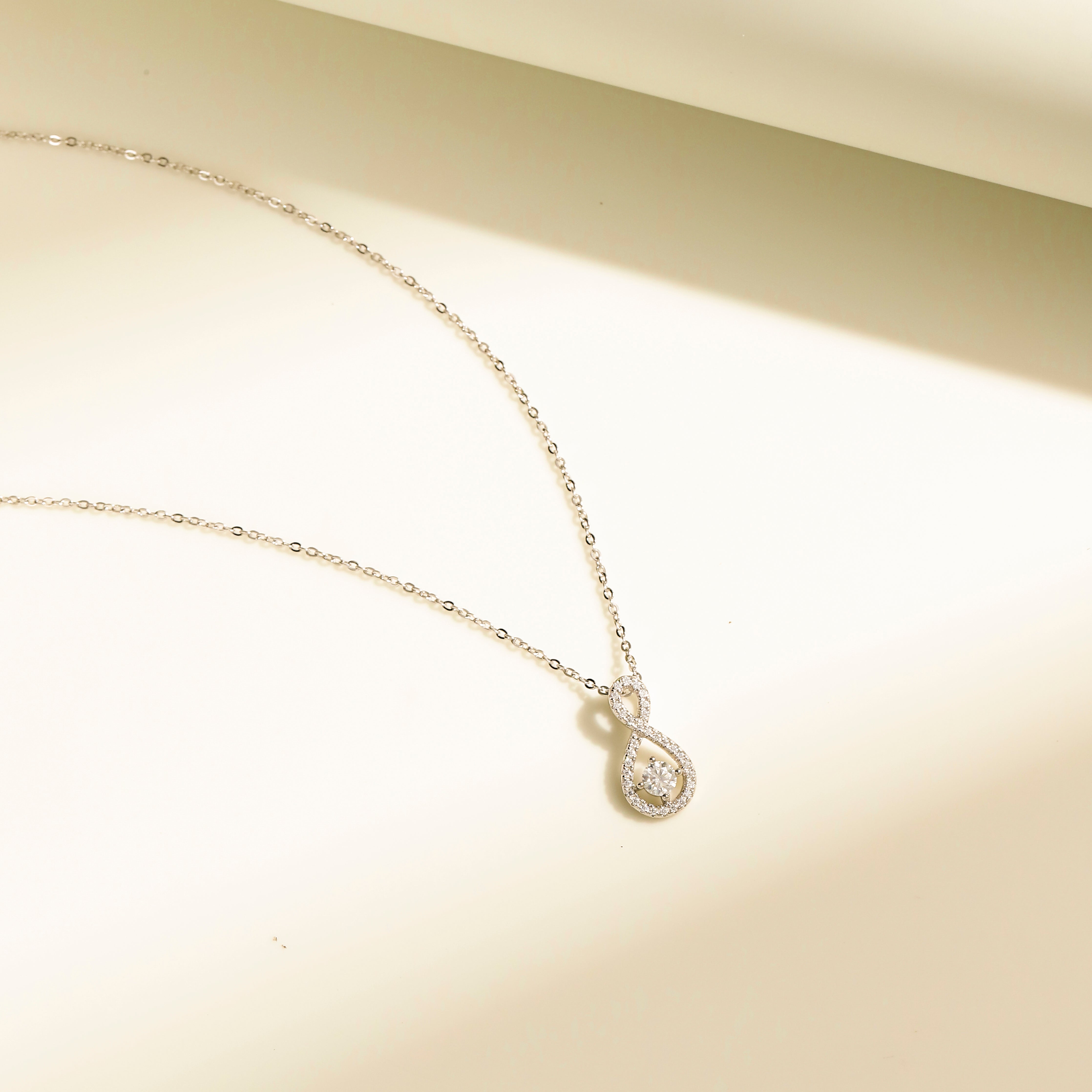 Eternal Loop Necklace in 18 carat white gold vermeil featuring an infinity loop design with a center Moissanite stone and adjustable chain, perfect for daily wear or as a thoughtful gift.