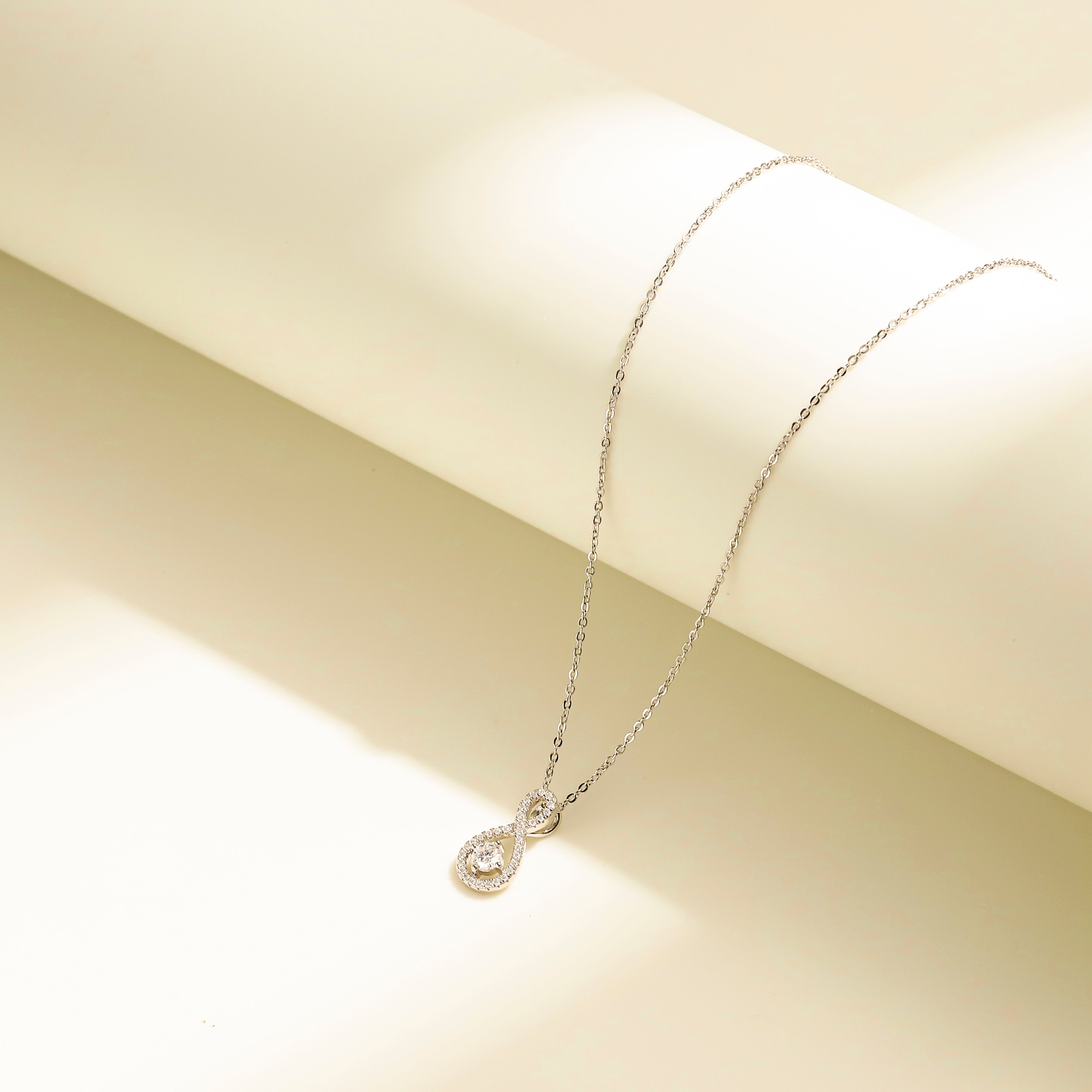 Eternal Loop Necklace in 18 carat white gold vermeil featuring an infinity loop design with a center Moissanite stone and adjustable chain, perfect for daily wear or as a thoughtful gift.