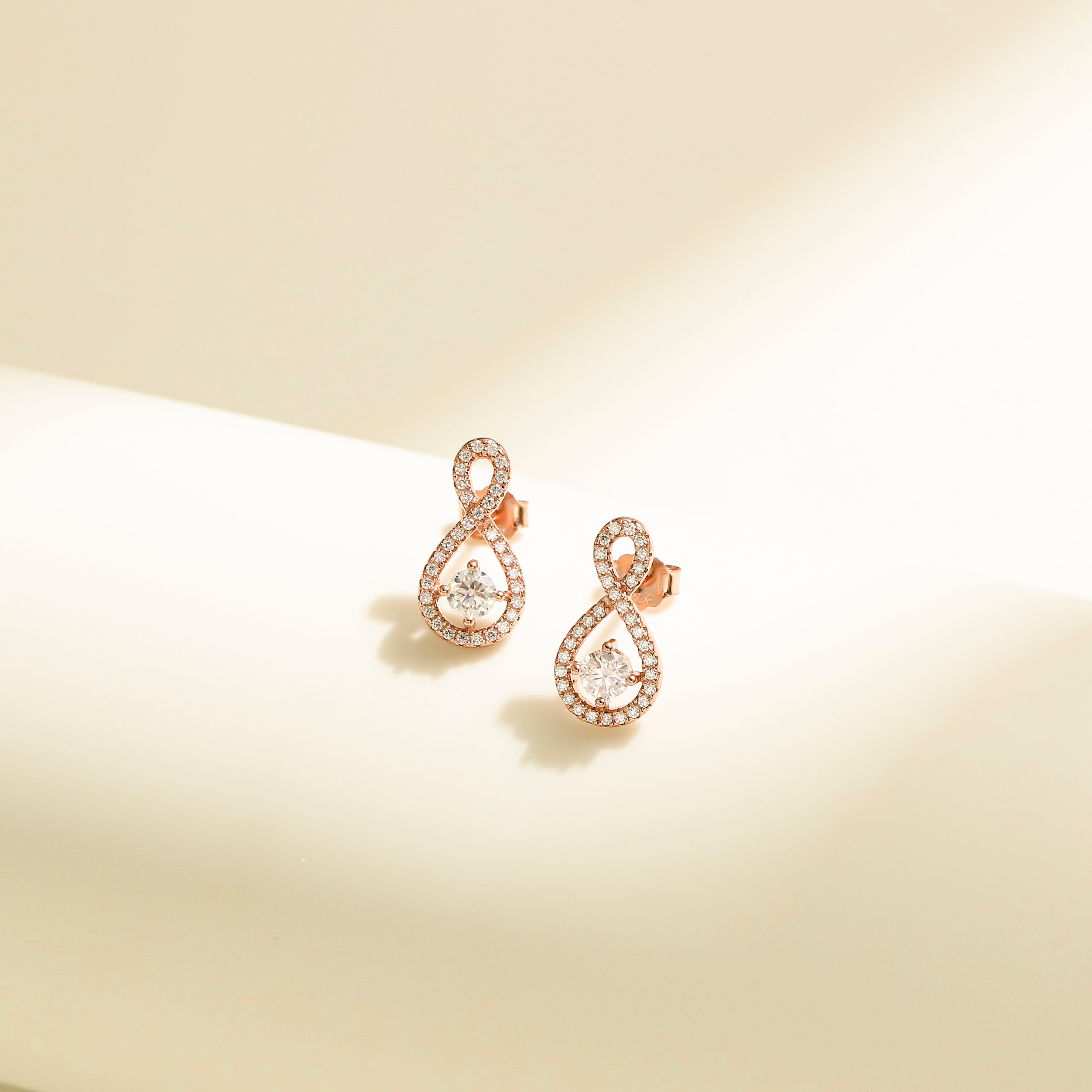 Elegant Loop Earring Studs in 18 carat rose gold vermeil, featuring an infinity loop design with a central Moissanite stone, perfect for daily wear or as a thoughtful gift.