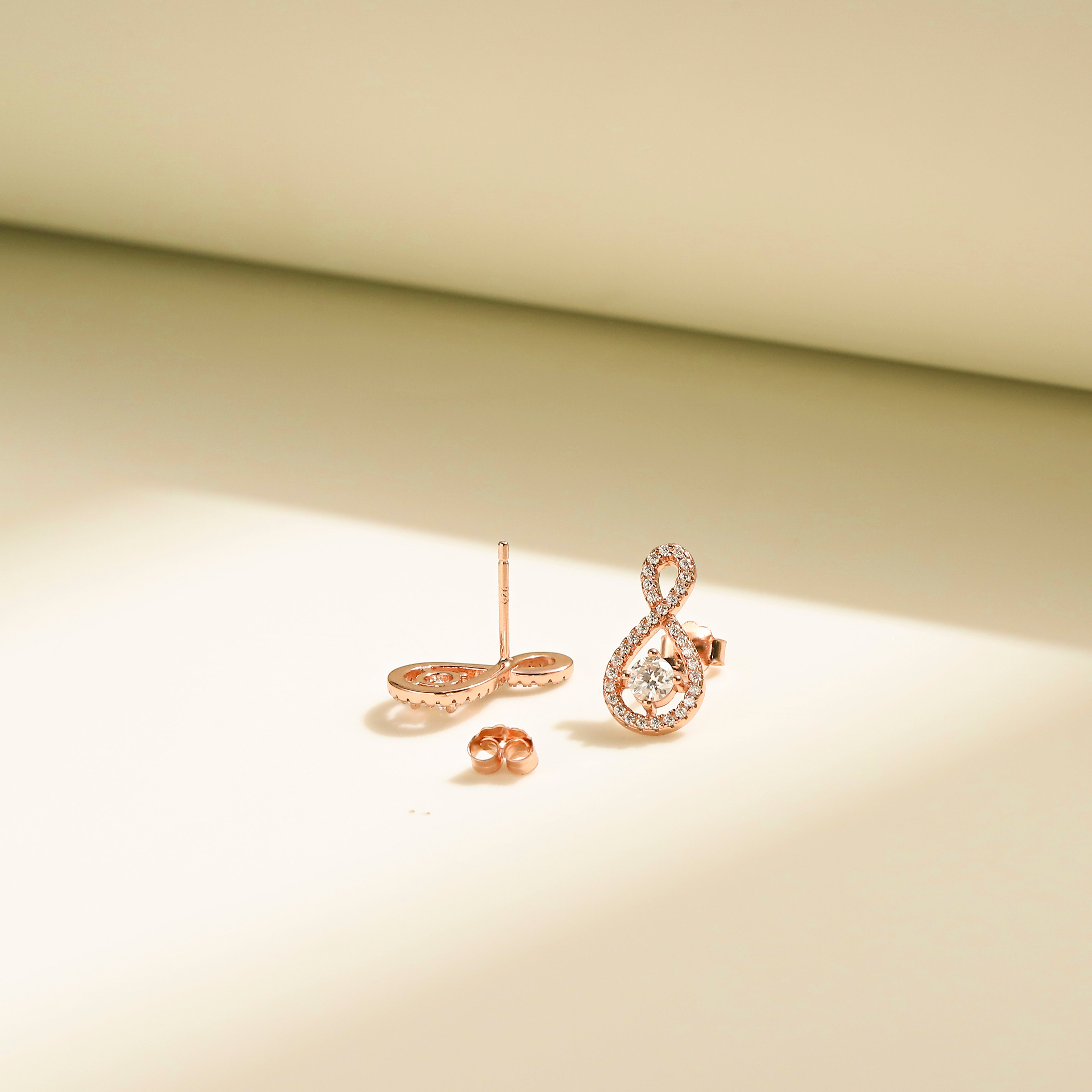 Elegant Loop Earring Studs in 18 carat rose gold vermeil, featuring an infinity loop design with a central Moissanite stone, perfect for daily wear or as a thoughtful gift.