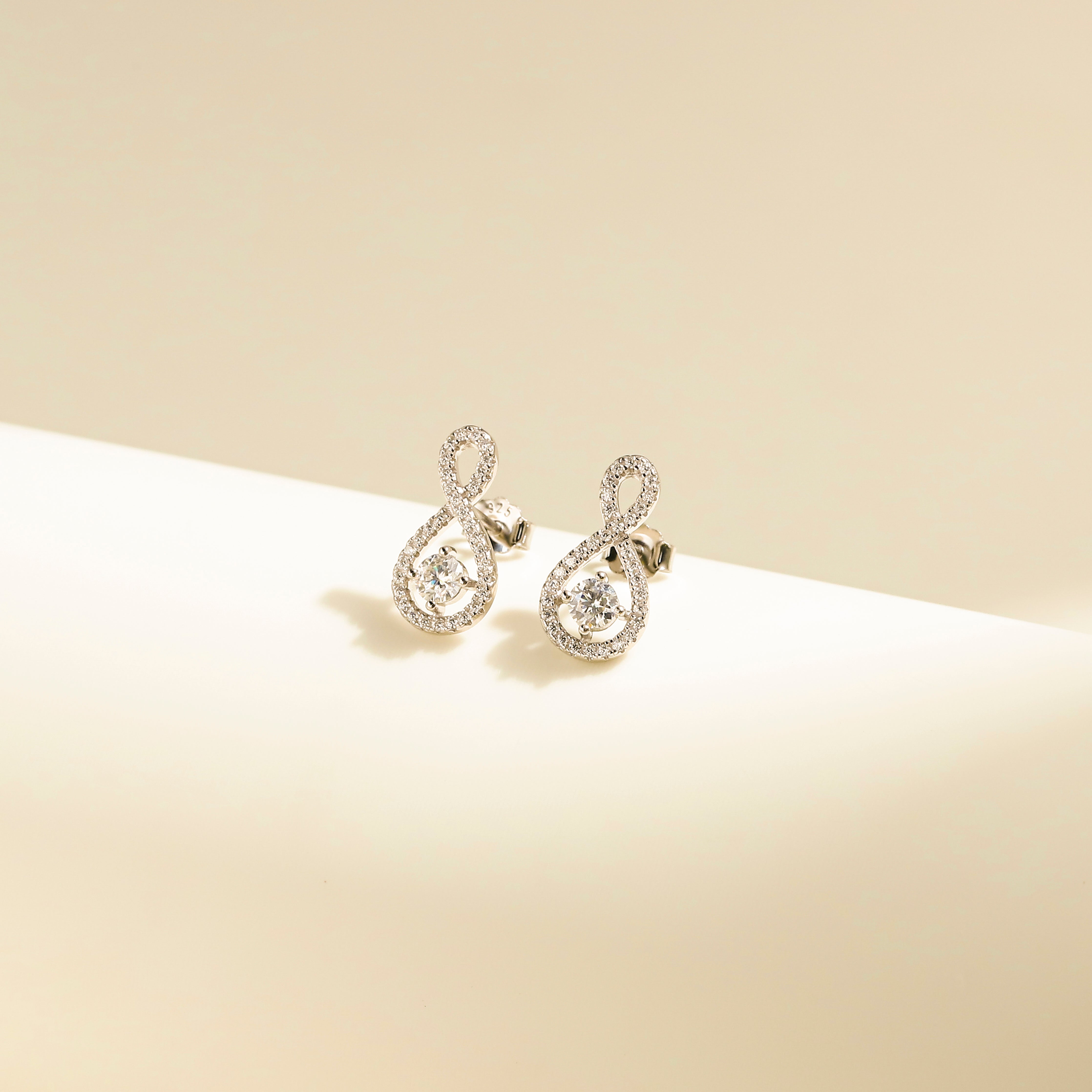 Elegant Loop Earring Studs in 18 carat white gold vermeil, featuring an infinity loop design with a central Moissanite stone, perfect for daily wear or as a thoughtful gift.