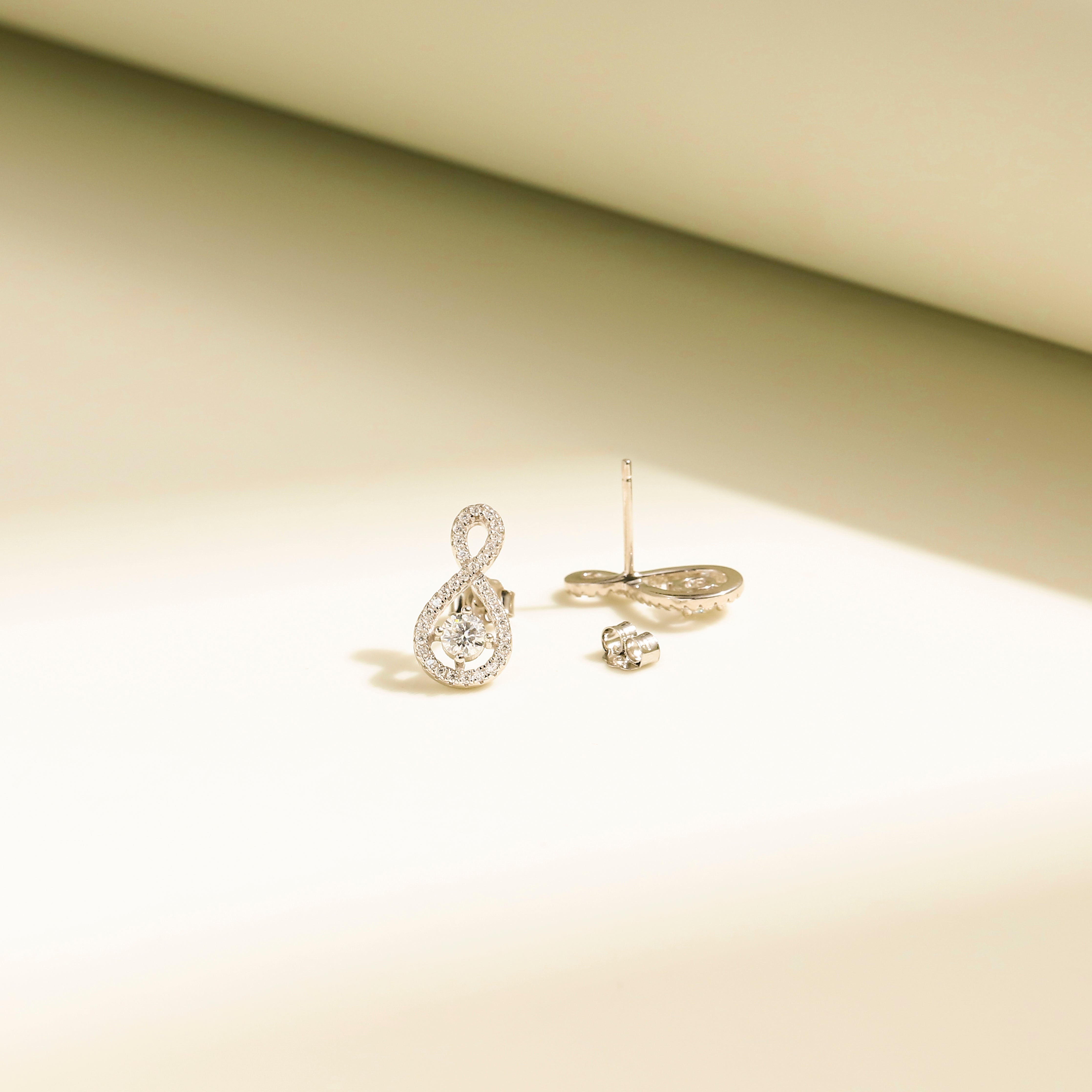 Elegant Loop Earring Studs in 18 carat white gold vermeil, featuring an infinity loop design with a central Moissanite stone, perfect for daily wear or as a thoughtful gift.