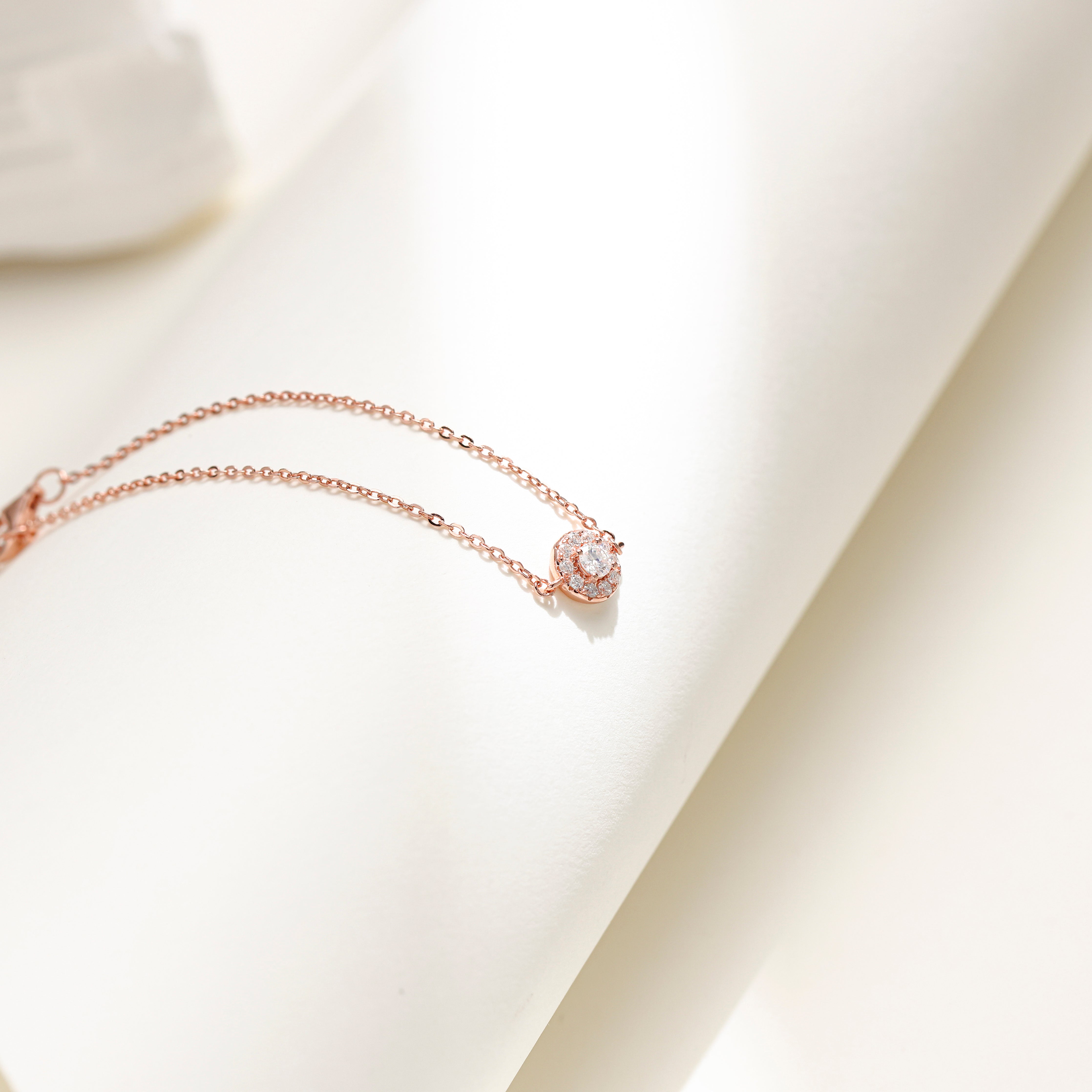 Minimalist Halo Charm Bracelet in 18 carat rose gold vermeil featuring a central Moissanite stone surrounded by a halo design, set on an adjustable chain, perfect for daily wear or as a thoughtful gift.